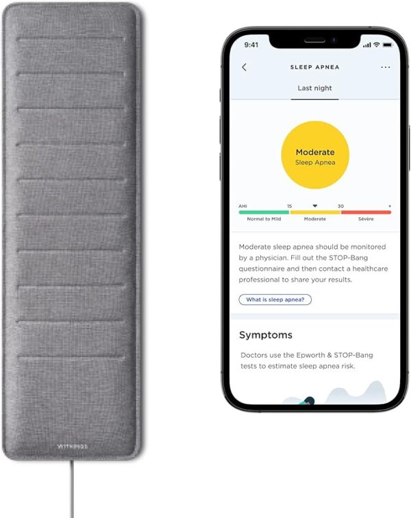 Grey Withings Sleep Analyzer pad partially visible under a mattress corner, with a smartphone displaying sleep data nearby.