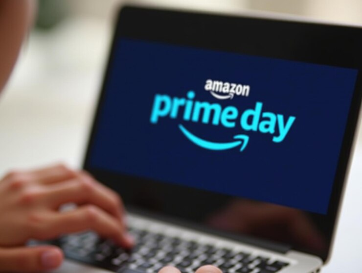 A hand touching a tablet screen displaying the Amazon Prime Day logo on a blue background.